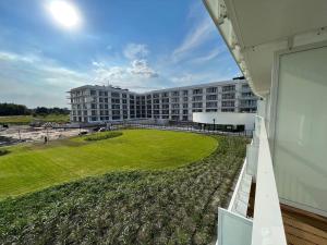 a large building with a green field in front of it at Polanki Aqua B 108 in Kołobrzeg