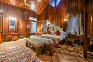 a hotel room with a bed, chair, table and lamps at Silver Sand Beach Resort Havelock in Havelock Island