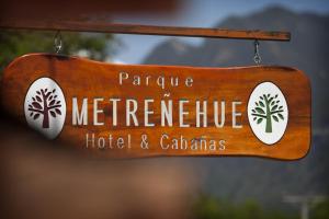 a wooden sign for a hotel and caciendas at Hotel Posada del Río - Parque Metreñehue in Pucón