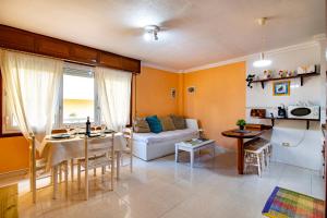 a living room with a couch and a table at Alquilaencanarias-Medano Tío Claudio beachfront in El Médano