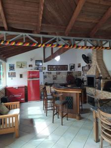 a kitchen with a red refrigerator and tables and chairs at iUP HOUSE Hostel in Blumenau