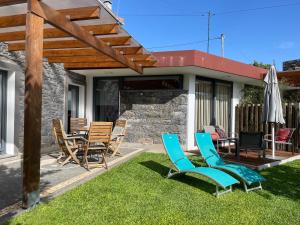 een terras met stoelen, een tafel en een parasol bij BHF Residences Ying Yang in Calheta