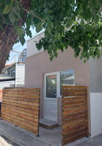 une maison avec une clôture en bois et une porte dans l'établissement Azalea, à Prilep