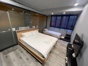 niewielka sypialnia z 2 łóżkami i oknem w obiekcie Yi Piao B&B w mieście Zhushan