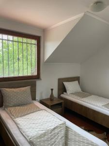 two beds in a room with a window at Holiday house Ilidza Sarajevo in Crkvine