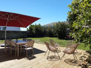 un patio con mesa, sillas y sombrilla en Charmante maison de plain pied avec 700m2 de jardin cloturé en Saint-Clément-des-Baleines