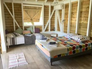 - une chambre avec 2 lits dans une pièce dotée de murs en bois dans l'établissement Cottages du Lagon, à Saint-François