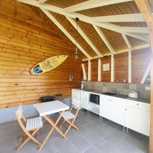 une cuisine avec une table et une planche de surf sur le mur dans l'établissement Cottages du Lagon, à Saint-François