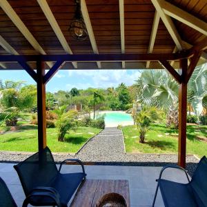 - une terrasse couverte avec des chaises et une vue sur la piscine dans l'établissement Cottages du Lagon, à Saint-François