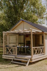 ein Haus mit einer Veranda mit einem Tisch in der Unterkunft Onlycamp Tours Val de Loire in Saint-Avertin