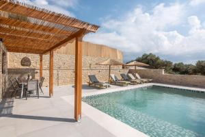 an outdoor patio with a swimming pool and a pergola at Alma Natura Villas Falasarna - Aposperitis Villa in Falasarna