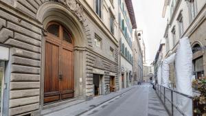 une rue vide dans une ruelle entre deux bâtiments dans l'établissement Casa Pavó Appartamento accanto al Bargello, à Florence