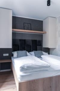 um quarto com 2 camas e lençóis brancos em Mobilna hiška pod Lipo em Velenje