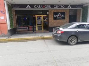 een zilveren auto geparkeerd voor een winkel bij CasaHotel Centro - Huancayo in Huancayo