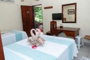una habitación de hotel con dos cisnes sentados en una cama en Hotel - Museo Xibalba, en Palenque