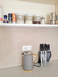una encimera con una estantería con tazones y utensilios de cocina en LE RIVE HOLIDAYS, en Desenzano del Garda