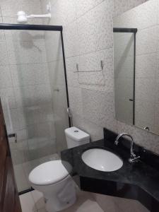 a bathroom with a toilet and a sink and a mirror at Pousada Sophia Beach in Salinópolis