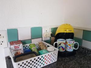 a toy kitchen with a counter with food and mugs at Chalés e flats Recanto Primavera in Camburi