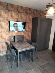 a dining room with a table and a tv on the wall at Hotel Beaurivage in Senigallia