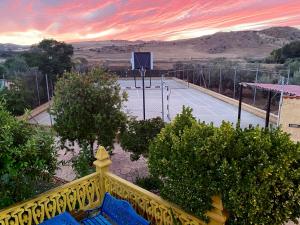アルダレスにあるFinca Villa Reyの黄色の柵と青いベンチのあるテニスコート