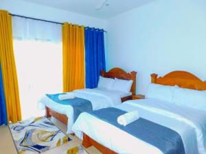 sypialnia z 2 łóżkami i oknem w obiekcie SWEET BREEZE HOMES w mieście Mombasa