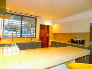 a kitchen with a table and a large window at SWEET BREEZE HOMES in Mombasa