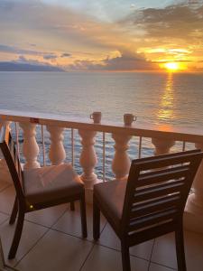 einen Balkon mit einem Tisch und Stühlen sowie einem Sonnenuntergang in der Unterkunft Costa Sur Resort & Spa in Puerto Vallarta