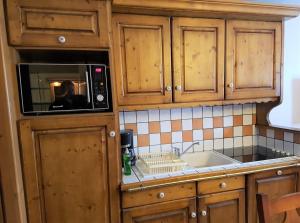 a kitchen with a microwave and a sink at Premium Les Alpages de Chantel in Arc 1800