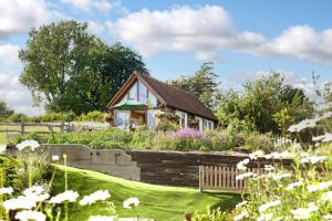 a small house in a garden with flowers at Observatory at South Downs Stay in Houghton