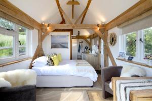 a bedroom with a white bed in a room with windows at Observatory at South Downs Stay in Houghton