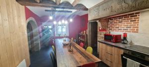 a kitchen with a wooden table and a brick wall at Gîte et SPA Chez Jules in Vellerot-lès-Vercel