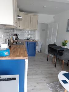a kitchen with blue and white cabinets and a table at Seaside Apartment with Seaview in Dublin 3 close to city centre in Dublin