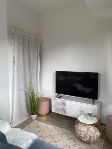 uma sala de estar com uma televisão de ecrã plano na parede em UrbanSuites - Modern & Zentral in der City - Dein Zuhause in Stuttgart em Stuttgart