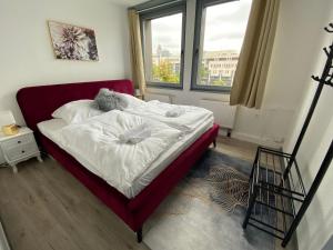 - une chambre avec un lit doté de draps blancs et une fenêtre dans l'établissement UrbanSuites - Modern & Zentral in der City - Dein Zuhause in Stuttgart, à Stuttgart