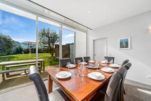 a dining room with a table and chairs and a large window at Lake Taupo Gem in Taupo