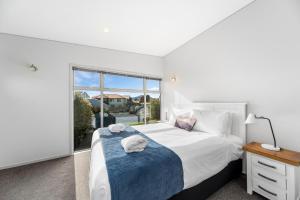 ein Schlafzimmer mit einem großen Bett und einem Fenster in der Unterkunft Lake Taupo Gem in Taupo