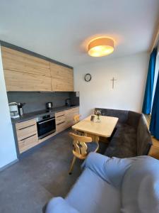cocina con sofá y mesa en una habitación en Aparts Handle und Haus Bergblick, en Pfunds