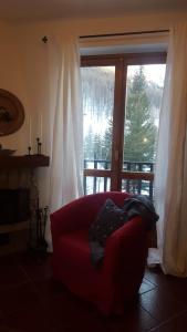 a red couch sitting in front of a large window at coeur de neige in Claviere