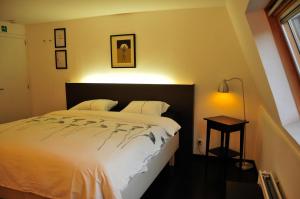 um quarto com uma cama, um candeeiro e uma janela em Logies Zen aan Zee em Oostende