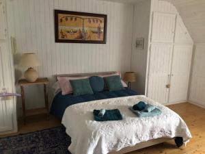 um quarto com uma cama com duas toalhas em Magnifique longère du Cotentin em Heugueville-sur-Sienne