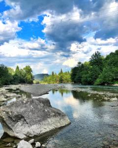 een rivier met een grote rots in het water bij Вершина Карпат in Krasnik