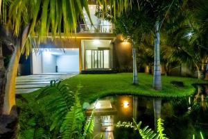 ein Haus mit einem Teich davor in der Unterkunft ISLAND RESIDENCE Plaisance - Mauritius - 15718 in Plaine Magnien