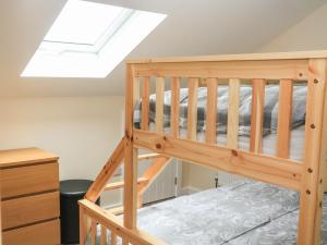 Cama elevada en habitación con tragaluz en Sawtons Cottage 2 en Dawlish