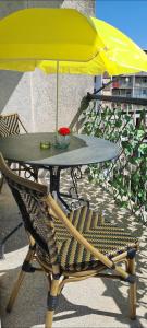 une table avec un parapluie jaune et une chaise dans l'établissement SmartStar, à Split