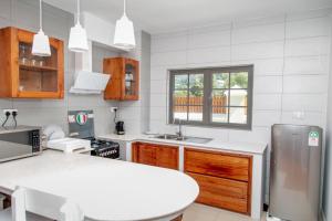 uma cozinha com um balcão branco e um lavatório em Phoenix Apartments em Victoria