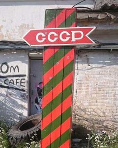 un palo rosso e verde con un cartello sopra di Back to USSR a Sillamäe