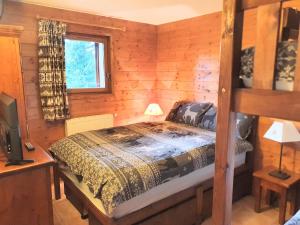 1 dormitorio con 1 cama en una cabaña de madera en Premium Les Alpages de Chantel, en Arc 1800