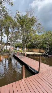 a wooden dock in a body of water with trees at Lencóis Ville Residence in Barreirinhas