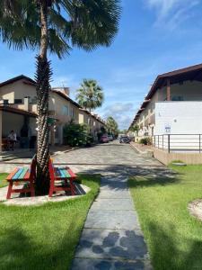 a street with two picnic tables next to a palm tree at Lencóis Ville Residence in Barreirinhas