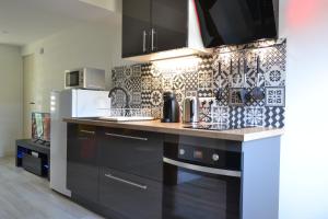 a kitchen with a black and white tiled wall at L'essentiel de Chartres in Chartres